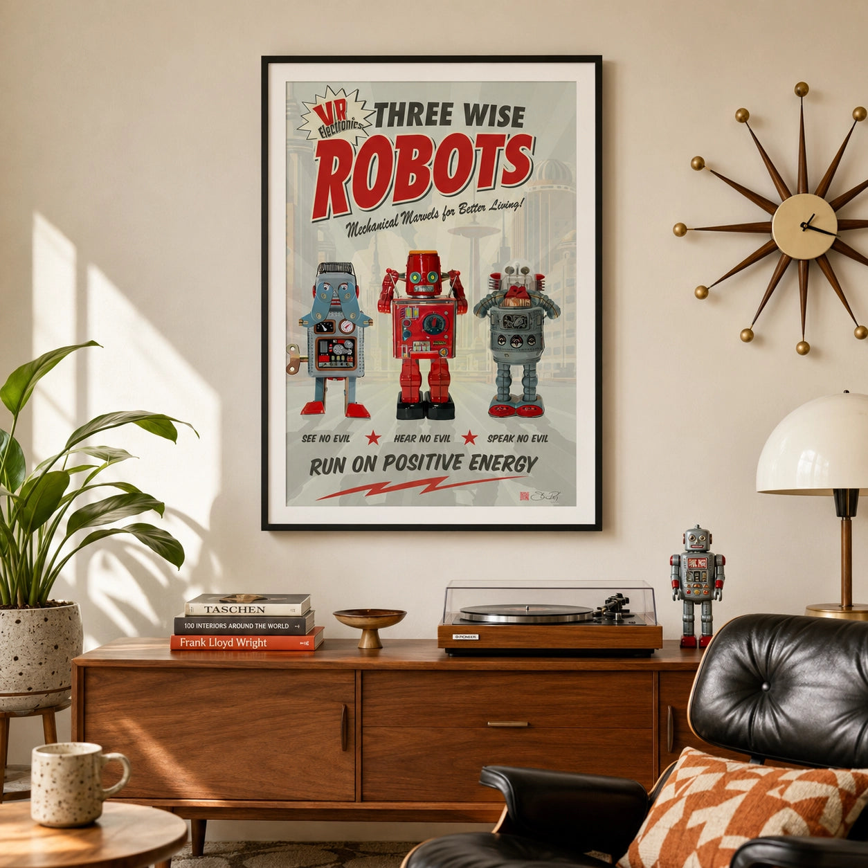 A framed retro-style poster reading 'Three Wise Robots' hangs on a beige wall above a wooden console table in a styled living room. The poster features three colorful robots, and the room includes a plant, lamp, chair, and starburst wall clock.